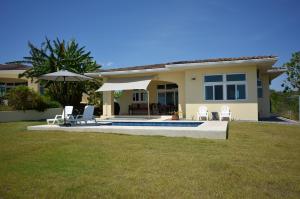 Casa con piscina, sillas y sombrilla en Casa Tanamera, en Boca Chica