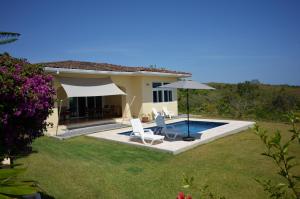 a villa with a swimming pool in a yard at Casa Tanamera in Boca Chica