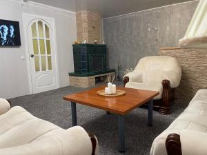 a living room with a table and chairs and a fireplace at Guest House Vilnius in Vilnius