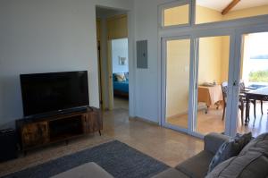 a living room with a flat screen tv on a wooden entertainment center at Casa Tanamera in Boca Chica