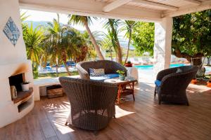 un patio con mesa, sillas y piscina en B&B Scacciapensieri, en Castellammare del Golfo