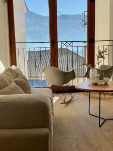 een woonkamer met een bank en een tafel en een groot raam bij Villa Christina in Ohrid