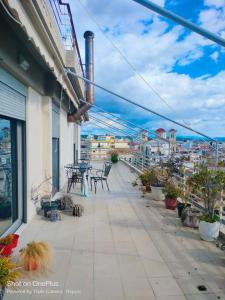 a balcony with tables and chairs on a building at Penthouse Pyrgos Centre Olympia in Pýrgos