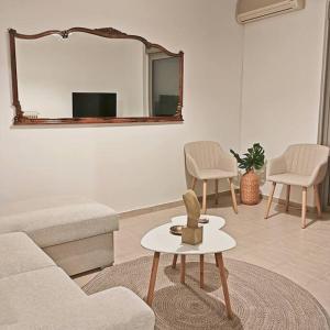 a living room with a couch and a mirror at Penthouse Pyrgos Centre Olympia in Pýrgos