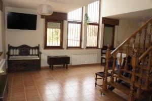 Una sala de estar con una cama y un televisor en la pared. en Mirador de San Marcos, en Soria