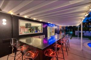 a bar with stools in a kitchen with a view at The Blush - with Pool, Bars, Neons! in Palm Springs