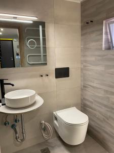 La salle de bains est pourvue de toilettes blanches et d'un lavabo. dans l'établissement Kyma Holiday Loft, à Artemi