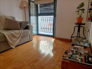 a living room with a couch and a wooden floor at Bonito y céntrico apartamento casco antiguo in Tarragona