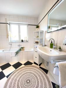 a white bathroom with a sink and a tub and a sinkessment at Step Apartments - Large, Luxurious and Central in Bad Aibling