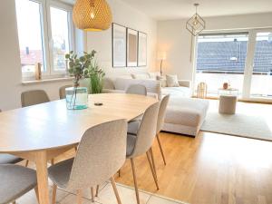 a living room with a wooden table and chairs at RONI APARTMENTS -111qm Luxury Loft -Near Center and Clinics -Netflix -Terrace -Close to Thermal Spa in Bad Aibling