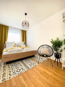 a bedroom with a bed and a chair at Step Apartments - Large, Luxurious and Central in Bad Aibling