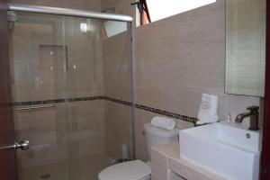 un bagno con doccia, WC e lavandino di Hotel Chapala Country a Chapala