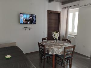 una sala da pranzo con tavolo e TV a parete di Namastè a Gasponi