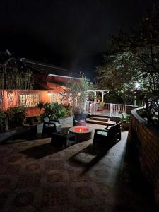 een patio met banken en 's nachts een vuurplaats bij Nina-Flor Pousada Lumiar in Lumiar