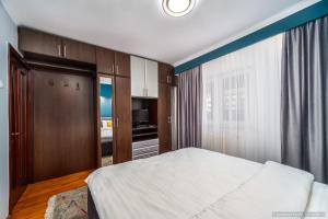 een slaapkamer met een groot bed en een keuken bij Apartament Nordic in Gura Humorului