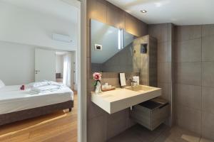 a bathroom with a sink and a bed at HEART OF TRENTO Loft & Rooms in Trento