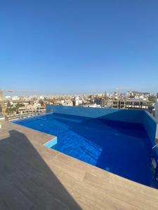 une piscine bleue sur le toit d'un bâtiment dans l'établissement Magnifique Appartement avec PISCINE, 3 Chambres, 4 Salles de Bain, Salle de Gym et Terrasse, LUXE ET COMFORT aux ALMADIES, à Dakar