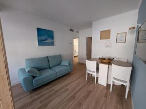 sala de estar con sofá azul y mesa en Apartamento vacacional Roda de Barà, en Roda de Bará