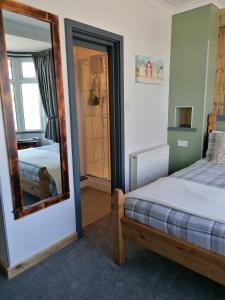 a bedroom with a bed and a mirror at Pensalda Guest House in Newquay