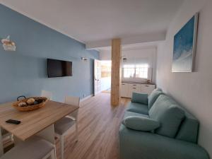 sala de estar con sofá azul y mesa en Apartamento vacacional Roda de Barà, en Roda de Bará