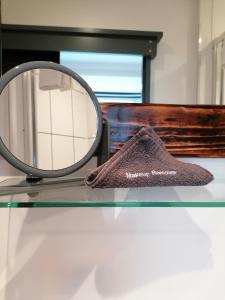 un espejo y una toalla sobre una mesa de cristal en Pensalda Guest House en Newquay