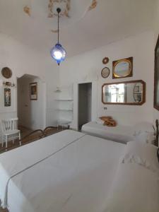 a white bedroom with two beds and a lamp at B&B Lido Liberty - "L'abbraccio di Klimt" in Lido di Ostia