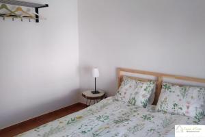 a bedroom with a bed and a lamp on a table at Casa D'Avó (1º Andar) in Altura