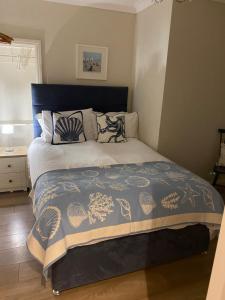a bedroom with a bed with a blue comforter at Downsfield Bed and Breakfast in St Ives