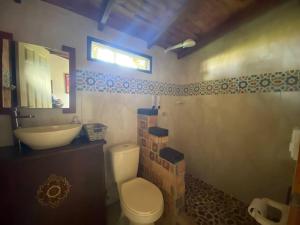 y baño con aseo, lavabo y espejo. en Finca exclusiva cerca a la reserva El Romeral en La Estrella