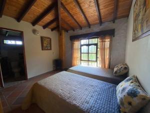 a bedroom with a large bed and a window at Finca exclusiva cerca a la reserva El Romeral in La Estrella