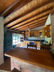 una gran cocina con una gran mesa de madera. en Finca exclusiva cerca a la reserva El Romeral, en La Estrella