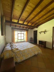 a bedroom with a large bed and a window at Finca exclusiva cerca a la reserva El Romeral in La Estrella