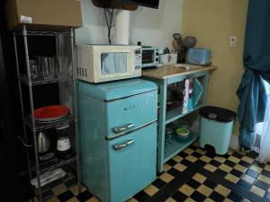 a kitchen with a microwave on top of an old refrigerator at Design District Wynwood Studio in Miami