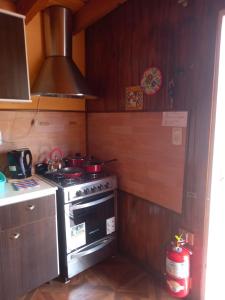 una cocina con fogones con ollas y sartenes. en Departamento LA LILI en Uspallata