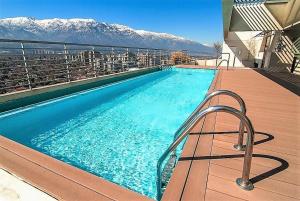 una piscina en la parte superior de un edificio con montañas en Moderno y Estiloso Excelente Ubicación, Las Condes, en Santiago