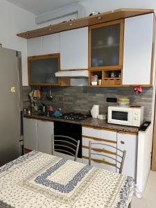 a kitchen with white cabinets and a table and a microwave at Appartamento in centro in Genova