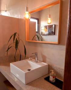 y baño con lavabo blanco y espejo. en Chalé Aurora da Serra - Lapinha da Serra en Santana do Riacho