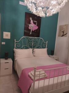 sypialnia z łóżkiem i żyrandolem w obiekcie B&B Il Siciliano w Syrakuzach