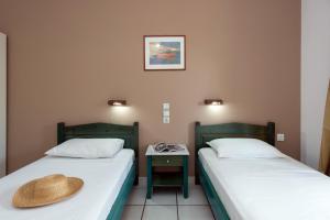 twee bedden in een kamer met een hoed op het bed bij Eriva Hotel in Acharavi
