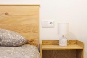1 dormitorio con cama y mesita de noche con lámpara en Cal Planell Casa Rural, en Vall-Llebrera