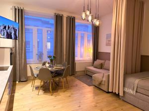 a living room with a dining table and a living room with a bed at Ferienwohnung Strandläufer in Wilhelmshaven