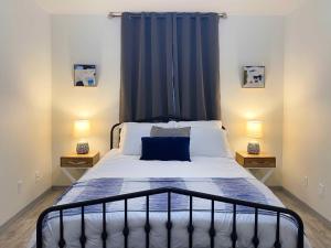 1 dormitorio con 1 cama con cortinas azules y 2 lámparas en Quiet 2BR 2BA, Laundry, Wi-Fi, Near Shops & Restos en McAllen