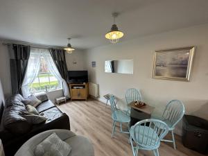 a living room with a couch and a table and chairs at Seascape Apartment in Filey