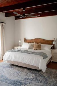 1 dormitorio con 1 cama grande y ventilador de techo en Melkhout Farm Cottage, en Bonnievale