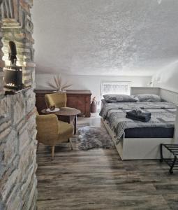 1 dormitorio con cama y pared de piedra en Sweet room with a terrace, en Roč