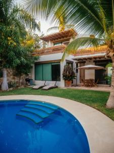 a house with a swimming pool in front of a house at Casa de la Luna in Puerto Escondido