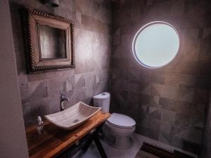 a bathroom with a sink and a toilet and a mirror at Casa de la Luna in Puerto Escondido