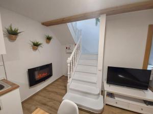 sala de estar con escalera, TV y chimenea en ARODRI SELLA, en Ribadesella