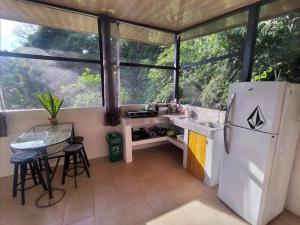 a kitchen with a refrigerator and a table at Cabinas fave in Uvita