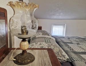 eine Lampe auf einem Holztisch neben einem Bett in der Unterkunft Sweet room with a terrace in Roč